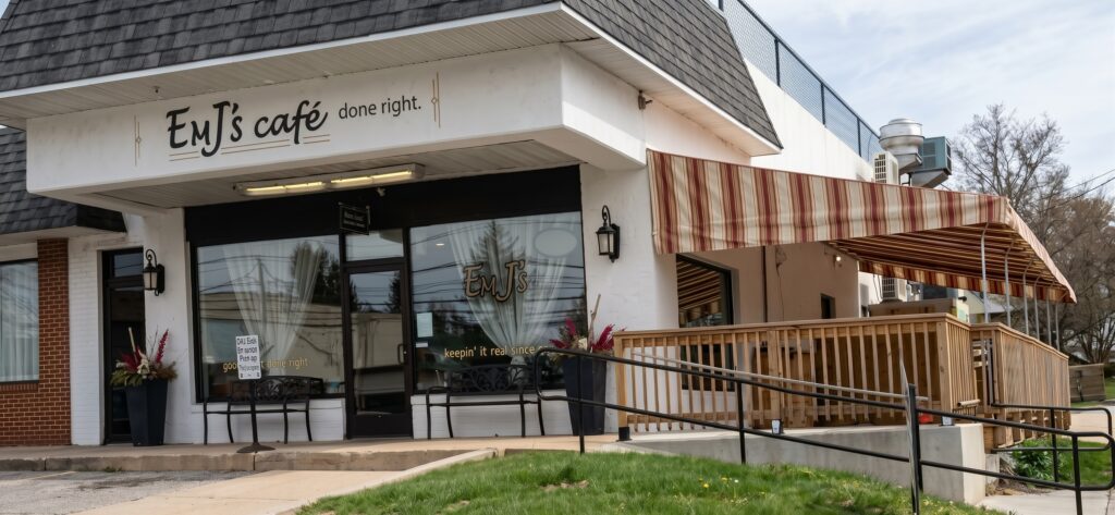 Commercial awning in white and burgundy attached to the side of EMJ's Cafe.